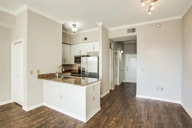 a kitchen with a sink cabinets and wooden floor
