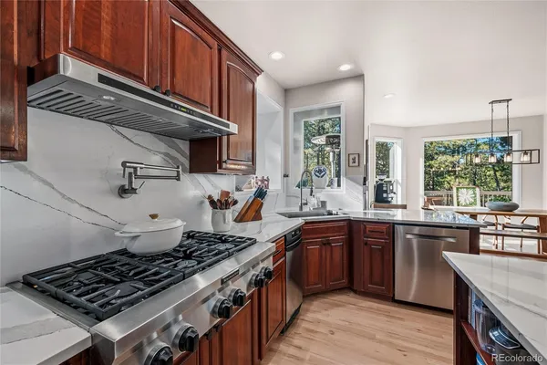 a kitchen with stainless steel appliances a sink a stove and cabinets