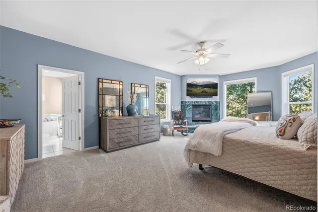 a bedroom with a large bed a flat tv screen and a fireplace