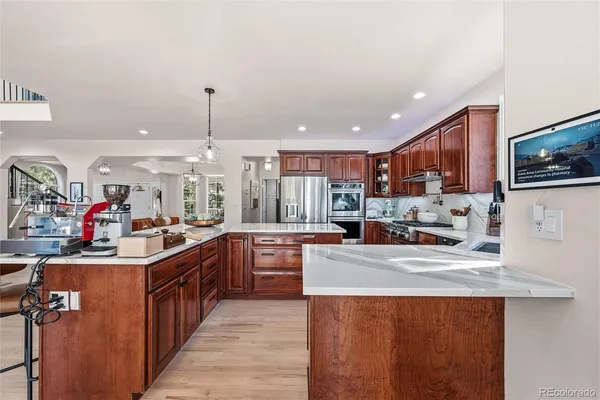 a kitchen with stainless steel appliances granite countertop a sink stove and refrigerator