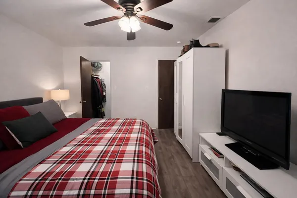 a bedroom with bed and flat screen tv