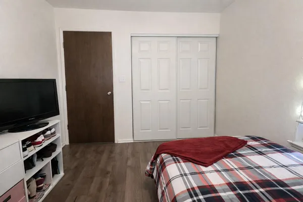a bedroom with a bed and a flat screen tv