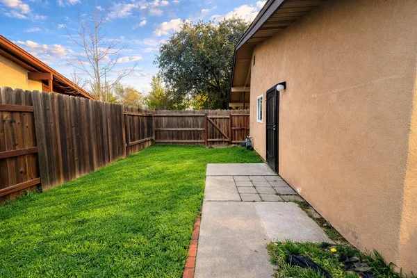 a view of a backyard with wooden fence