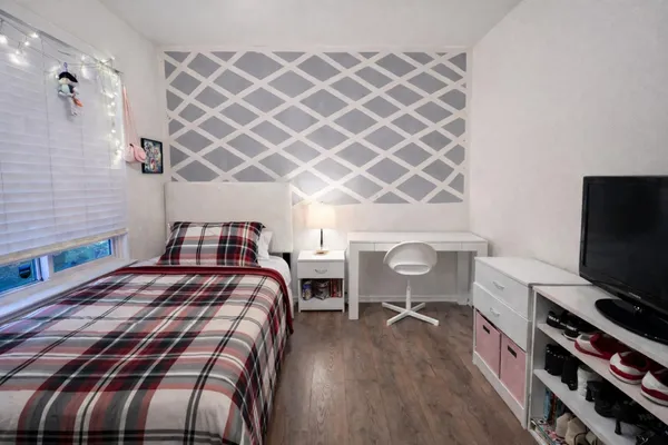 a bedroom with a bed and a flat screen tv
