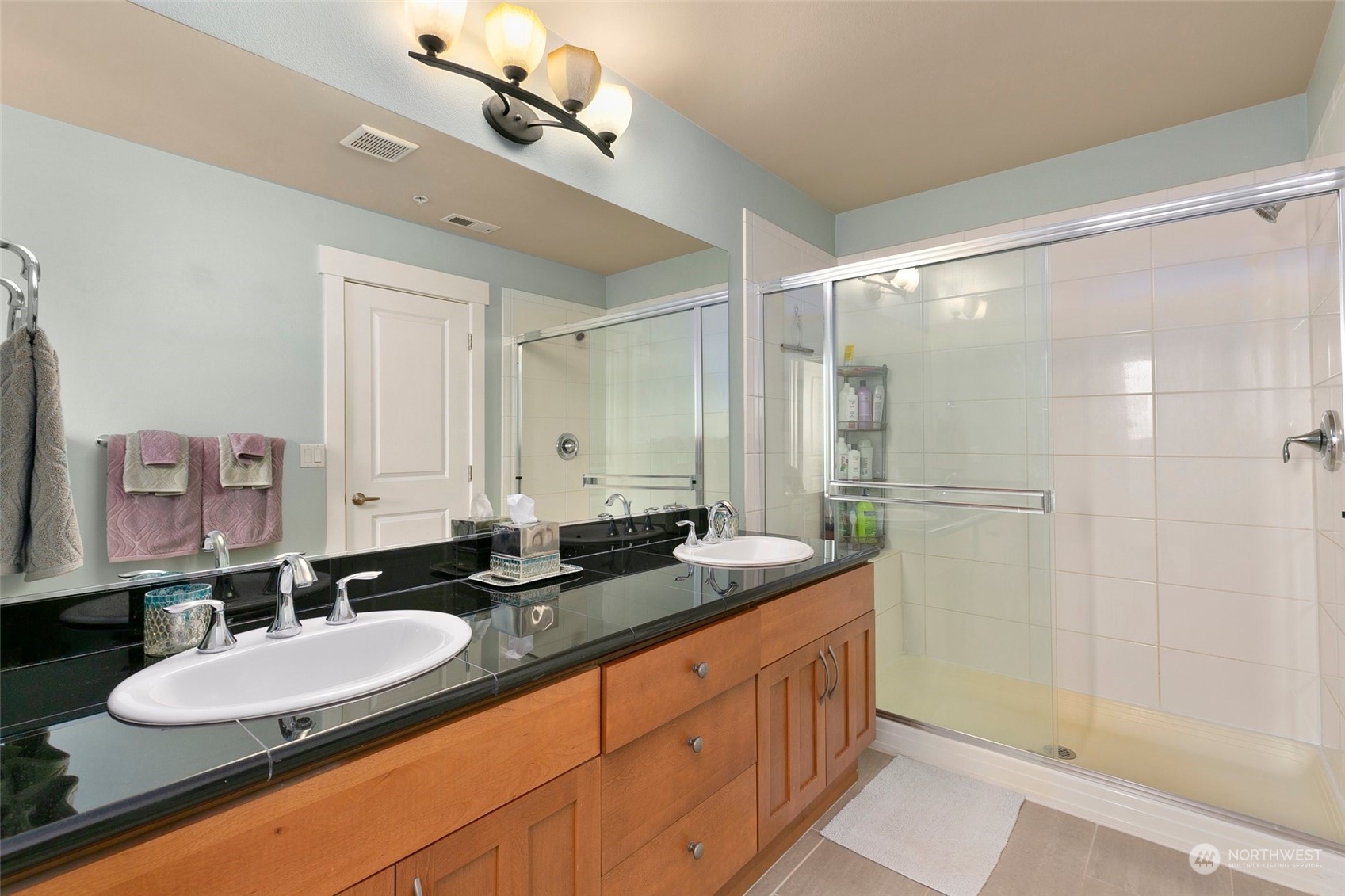2115 201st Place Southeast, Unit B3 Bothell, WA 98012 - Photo 19 of 25 a bathroom with a double vanity sink and a mirror