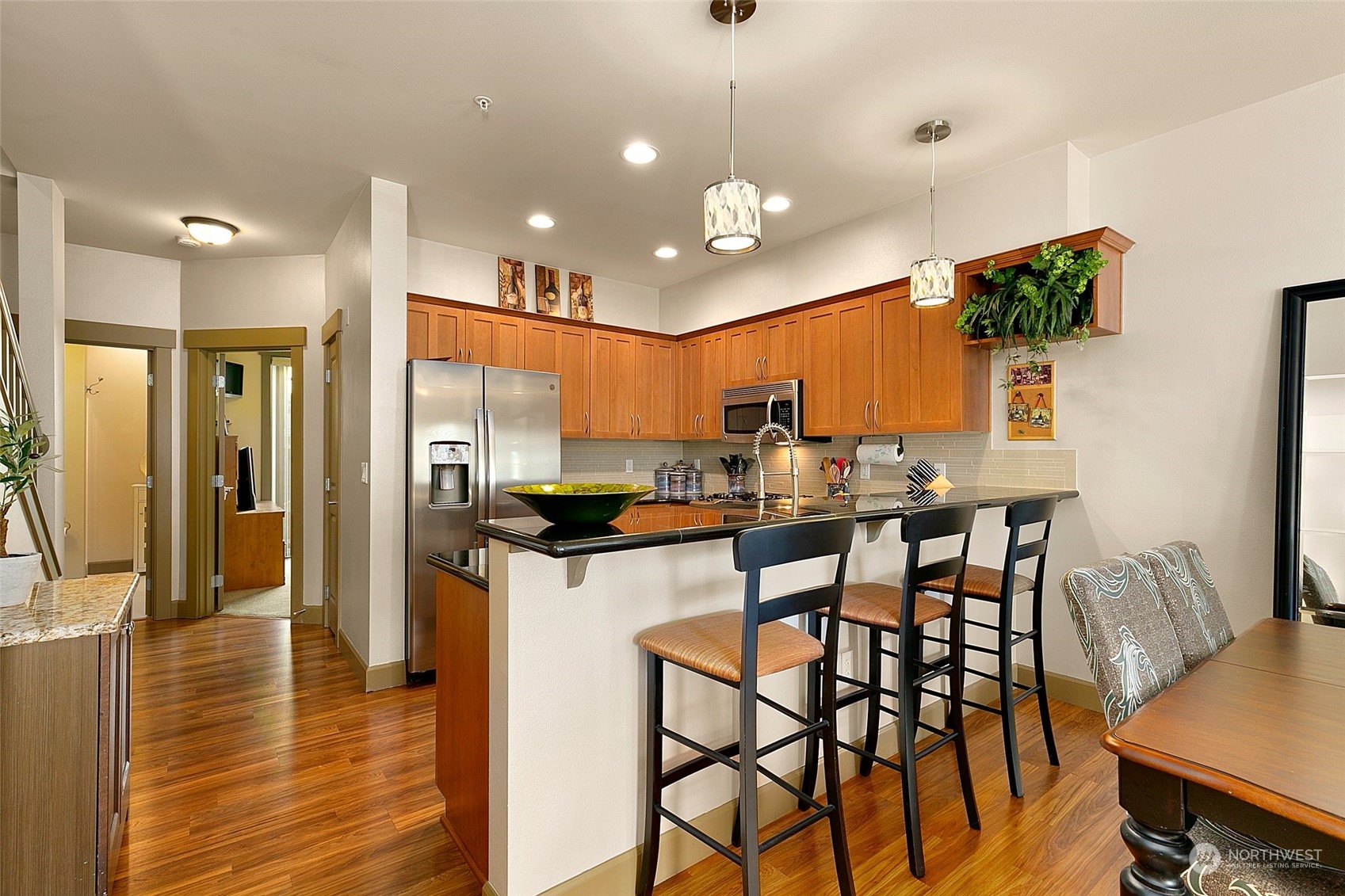 2115 201st Place Southeast, Unit B3 Bothell, WA 98012 - Photo 8 of 25 a kitchen with stainless steel appliances kitchen island granite countertop a table chairs and a refrigerator
