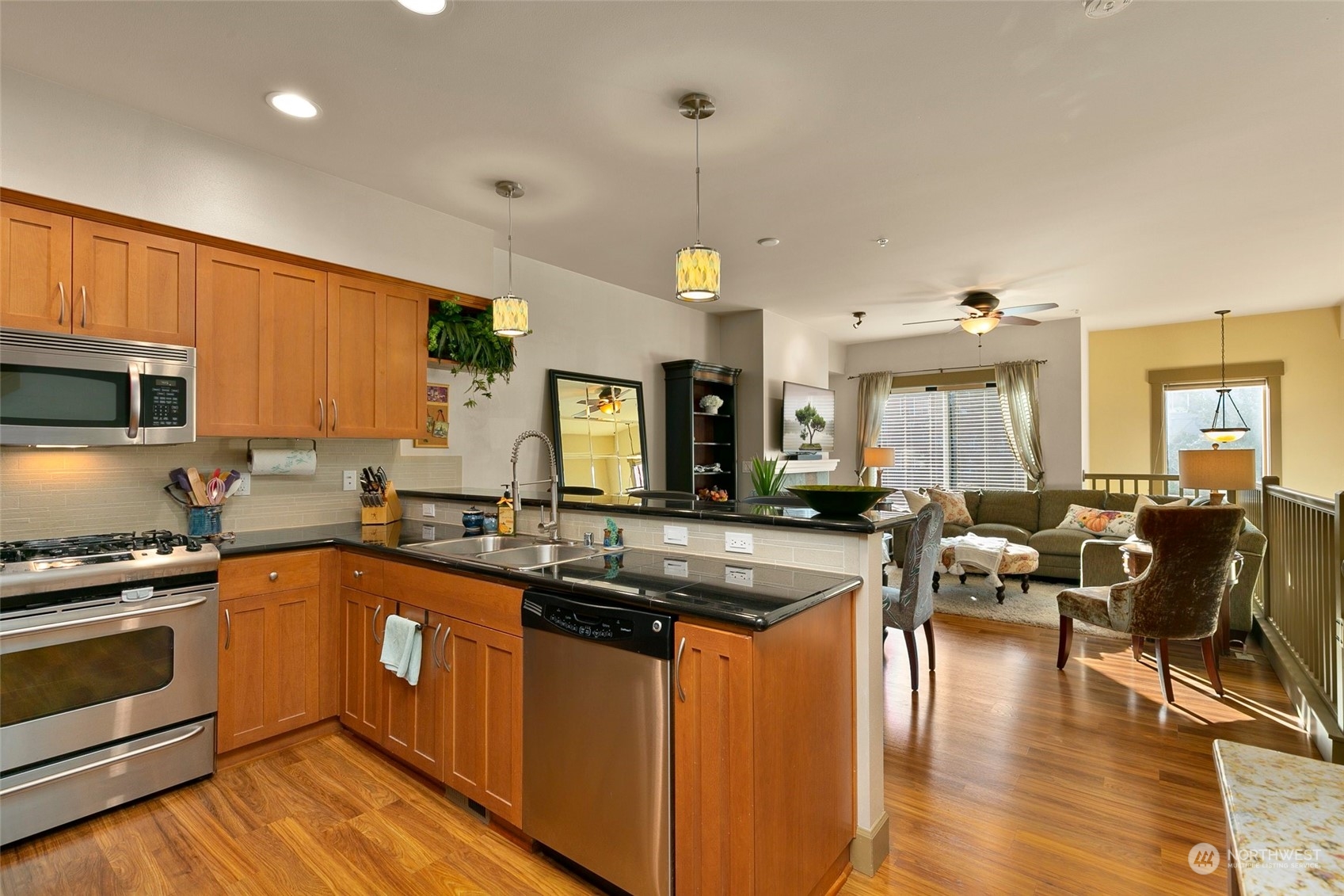 2115 201st Place Southeast, Unit B3 Bothell, WA 98012 - Photo 10 of 25 a kitchen with granite countertop a stove top oven a sink dishwasher and white cabinets with wooden floor