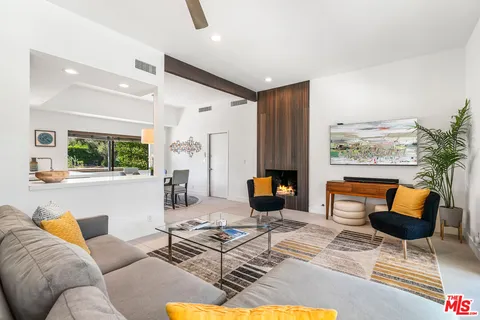 a living room with furniture kitchen view and a large window
