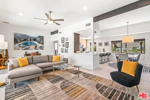 a kitchen with a sink a window and chairs