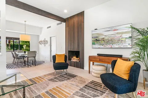 a kitchen with stainless steel appliances kitchen island granite countertop a sink a stove and a dining table with wooden floor