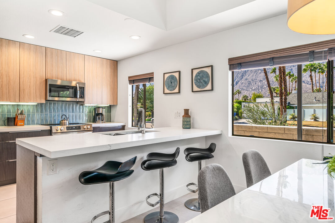 544 North Tercero Circle Palm Springs, CA 92262 - Photo 21 of 75 a kitchen with a sink a window and chairs