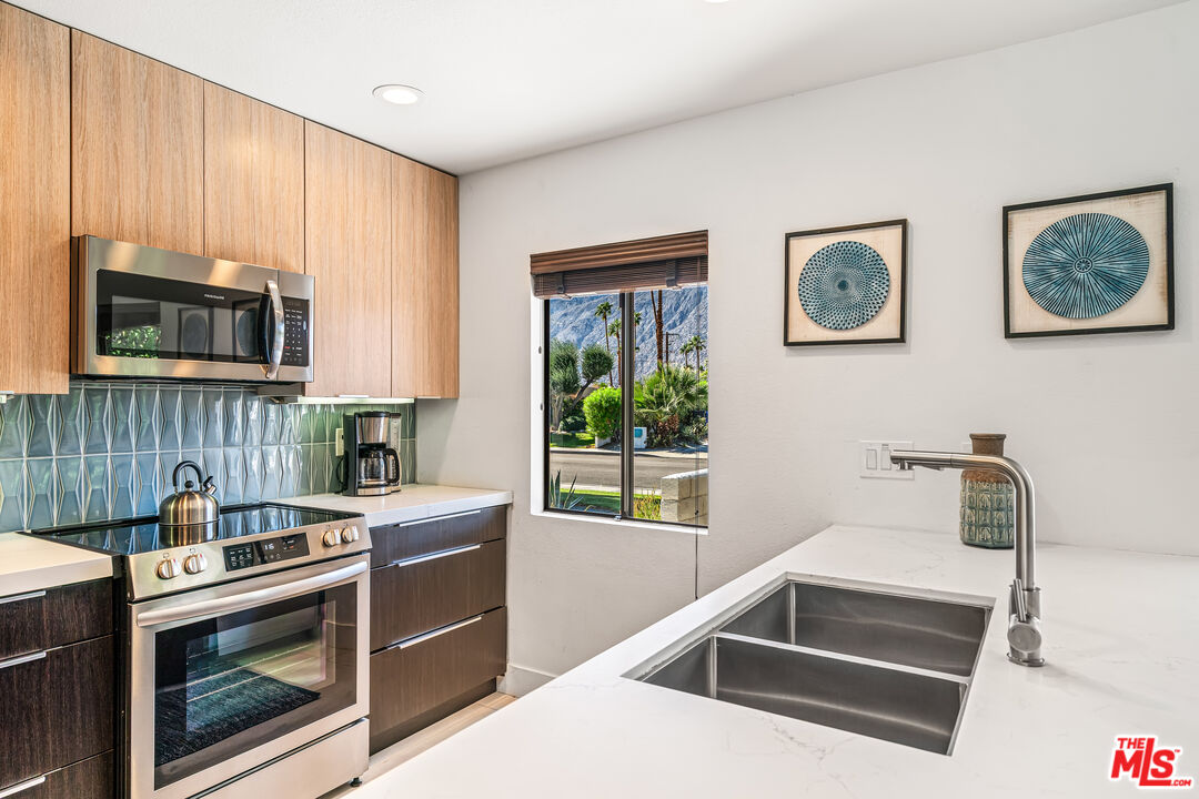 544 North Tercero Circle Palm Springs, CA 92262 - Photo 26 of 75 a kitchen with stainless steel appliances a stove a microwave a sink and cabinets