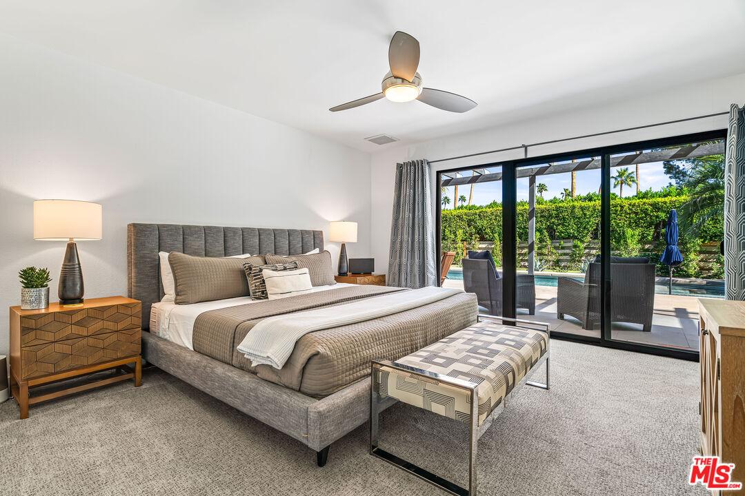 544 North Tercero Circle Palm Springs, CA 92262 - Photo 36 of 75 a bedroom with a bed lamp and a large window with balcony view