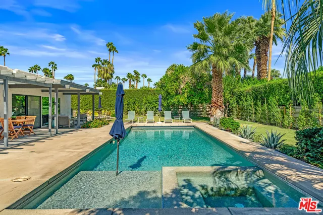 a view of a swimming pool with a patio and a yard