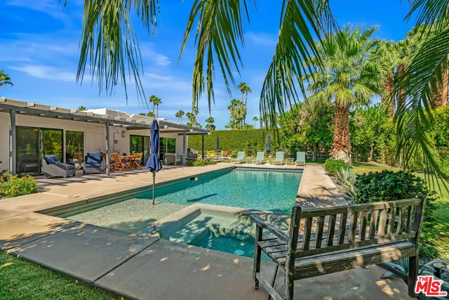 a view of a patio with table and chairs potted plants and palm tree