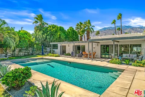 a backyard of a house with table and chairs