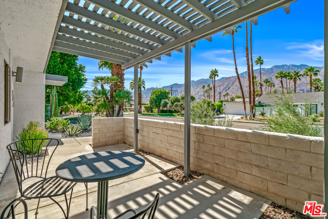 544 North Tercero Circle Palm Springs, CA 92262 - Photo 7 of 75 a view of a patio with table and chairs potted plants with wooden floor and fence