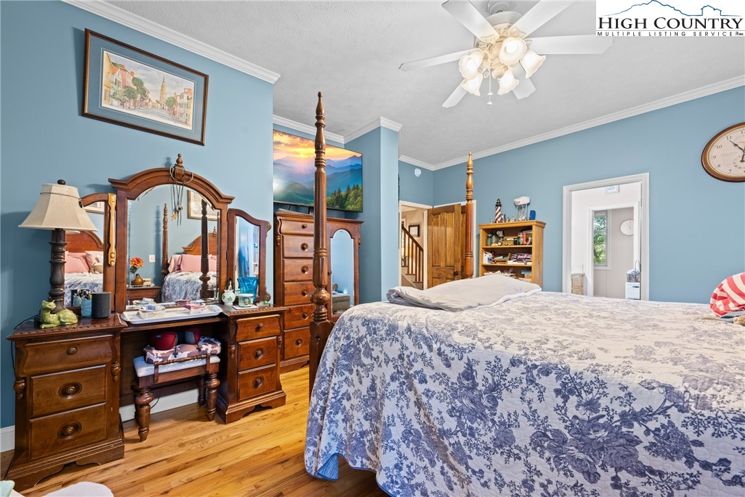 126 Moore Mountain Road Vilas, NC 28692 - Photo 17 of 43 a bedroom with a bed and a chandelier