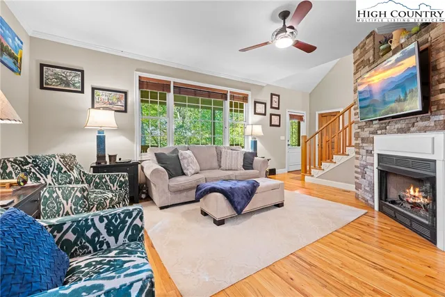 a living room with furniture a flat screen tv and a fireplace