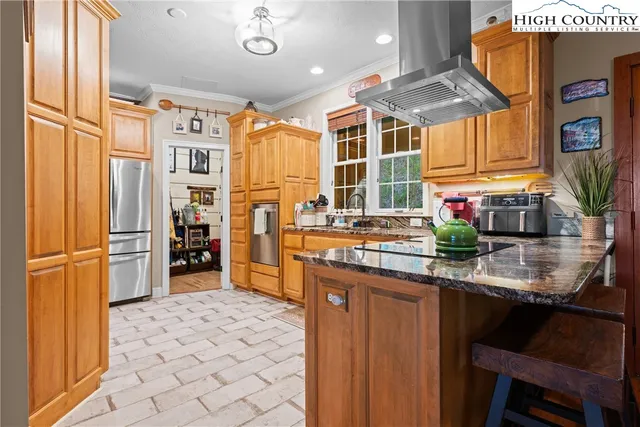 a kitchen with stainless steel appliances granite countertop a sink and a refrigerator