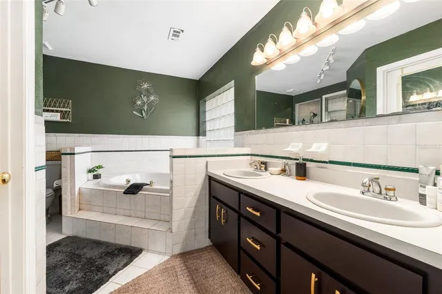 a bedroom with bed and a flat tv screen on dresser