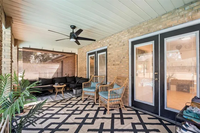 a living room with furniture a flat screen tv and a floor to ceiling window