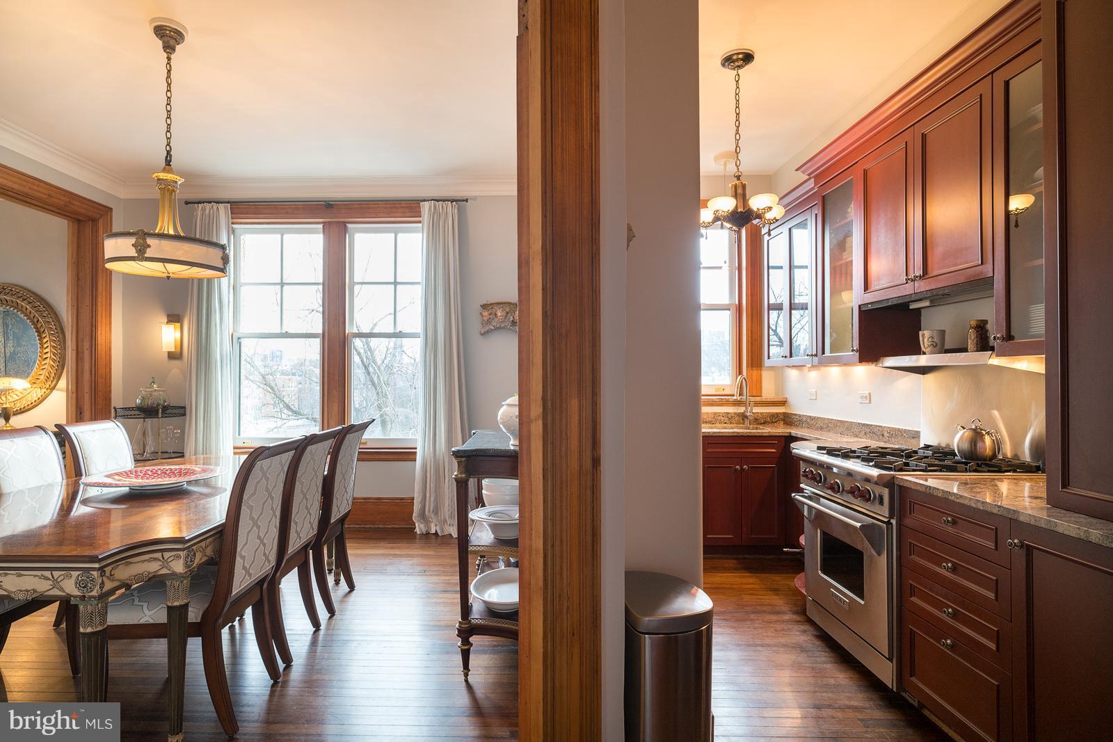 2853 Ontario Road Northwest, Unit 421 Washington, DC 20009 - Photo 14 of 35 a kitchen with stainless steel appliances granite countertop a stove top oven a sink a dining table and chairs with wooden floor