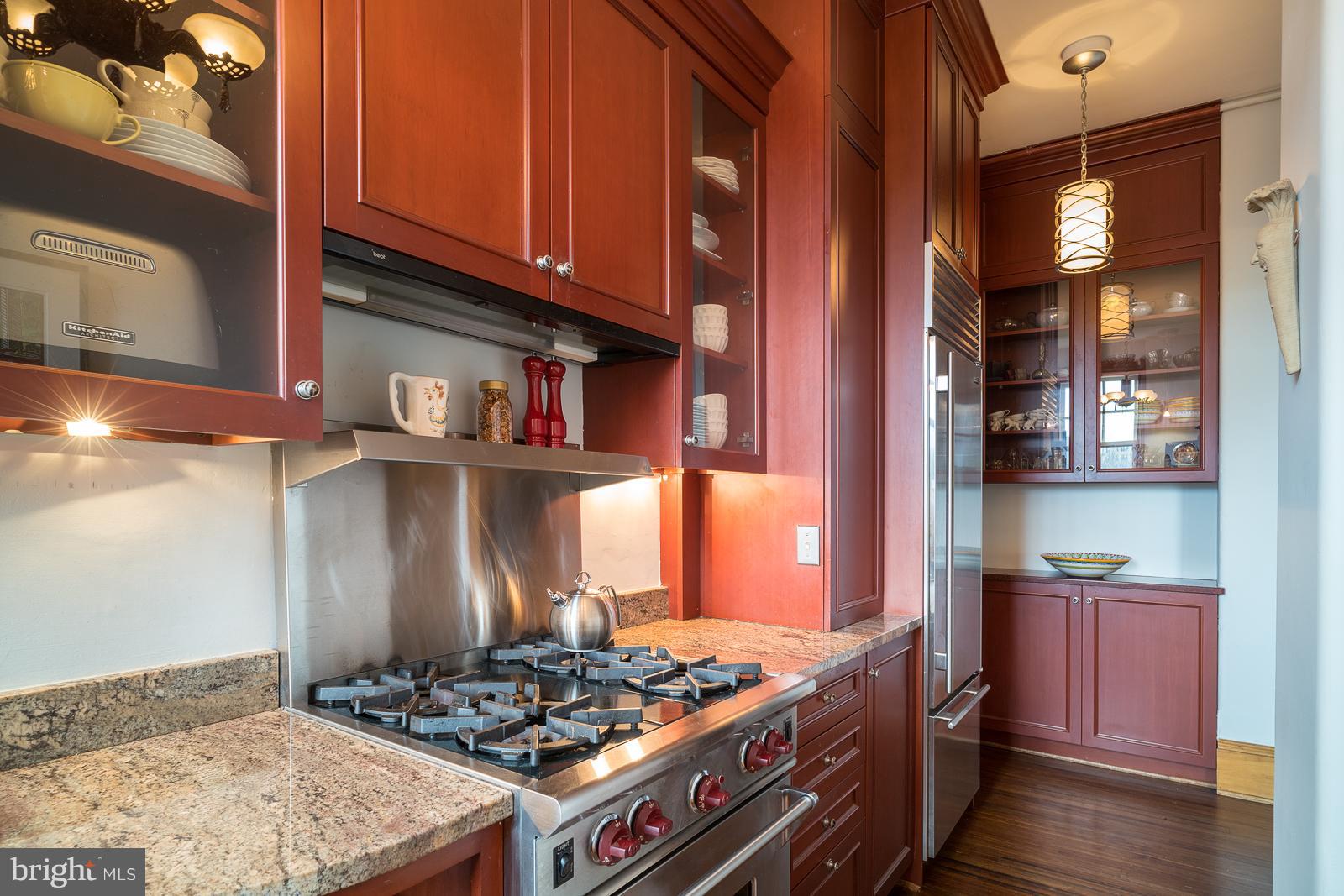 2853 Ontario Road Northwest, Unit 421 Washington, DC 20009 - Photo 17 of 35 a kitchen with stainless steel appliances granite countertop a stove and a wooden cabinets