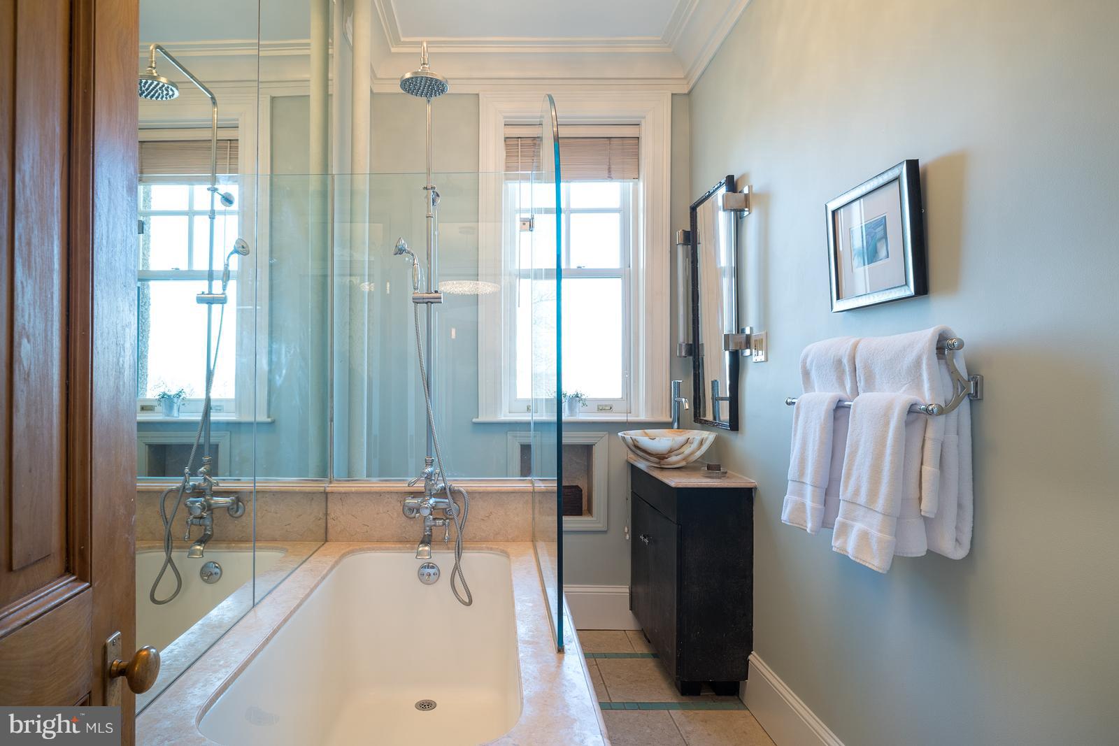 2853 Ontario Road Northwest, Unit 421 Washington, DC 20009 - Photo 21 of 35 a bathroom with a tub sink and mirror