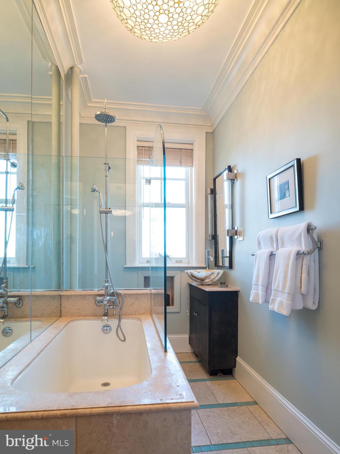 2853 Ontario Road Northwest, Unit 421 Washington, DC 20009 - Photo 22 of 35 a bathroom with a tub sink and mirror