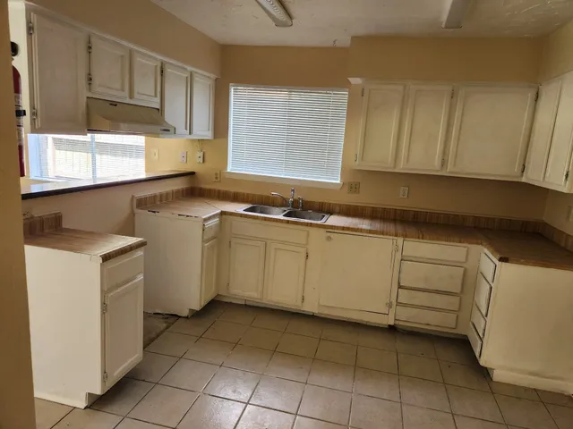 a kitchen with a sink window and cabinets