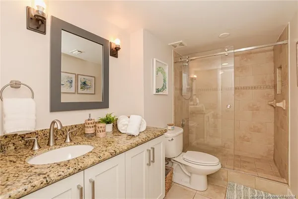 a spacious bedroom with a bed and a chandelier