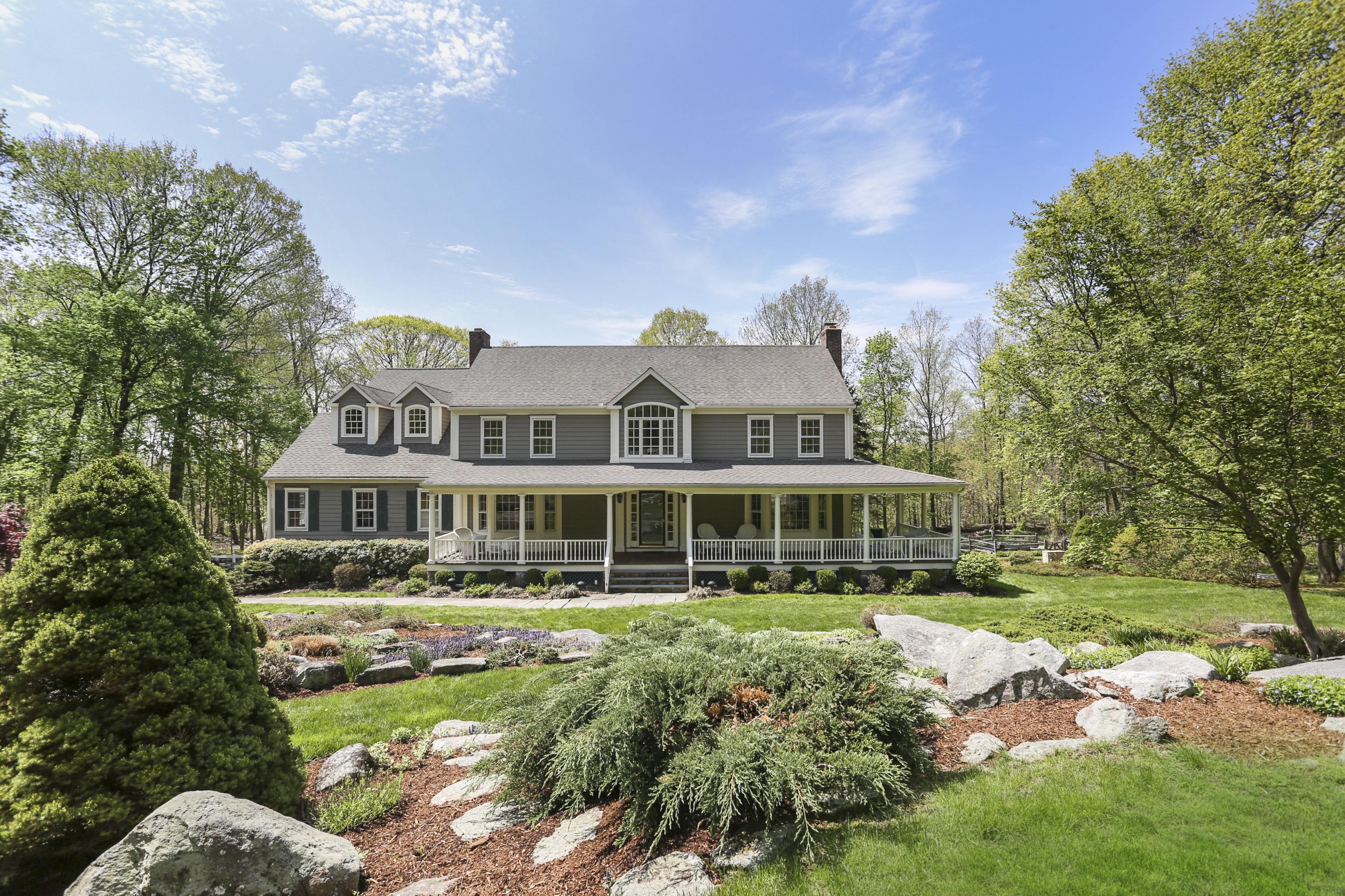 209 Brushy Ridge Road New Canaan, CT 06840 - Photo 1 of 25 a front view of a house with a garden and lake view