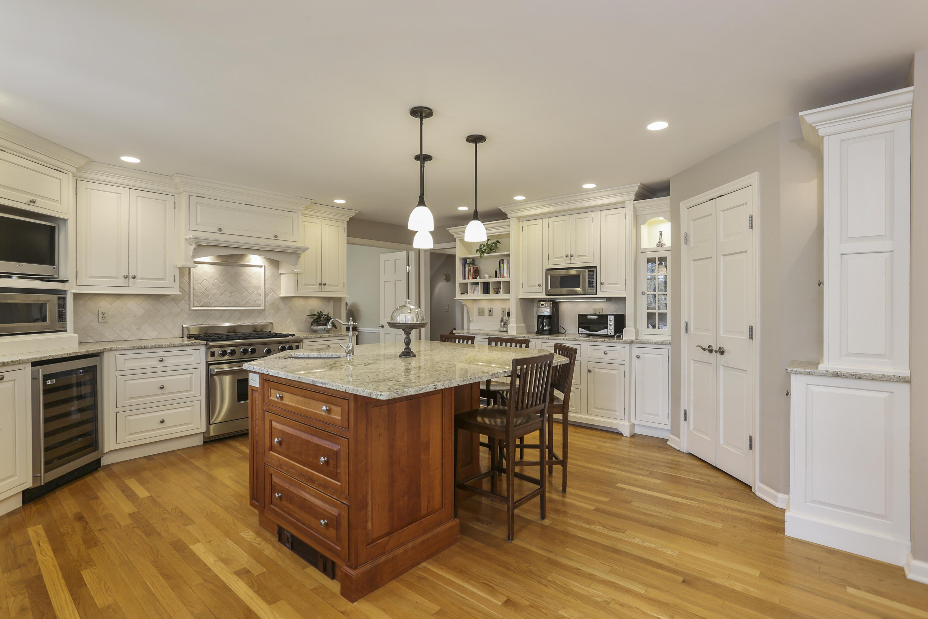 209 Brushy Ridge Road New Canaan, CT 06840 - Photo 8 of 25 a kitchen with stainless steel appliances granite countertop a stove top oven a refrigerator a sink and a dining table with wooden floor