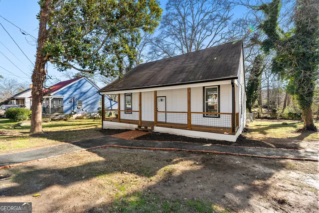 a view of a hallway with wooden floor and a bathroom