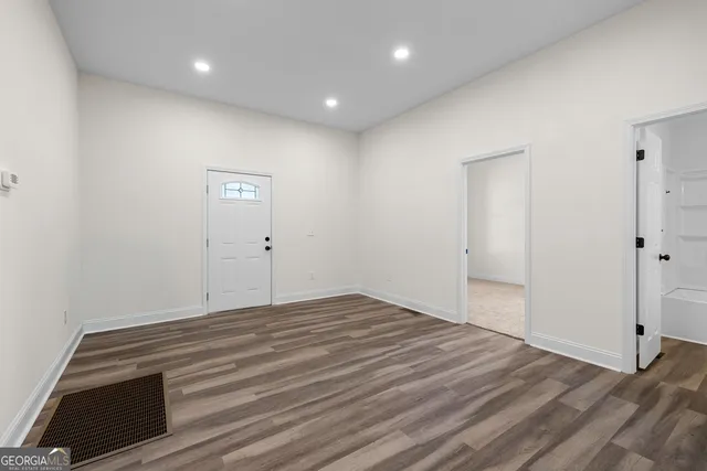 a view of an empty room with closet and entryway