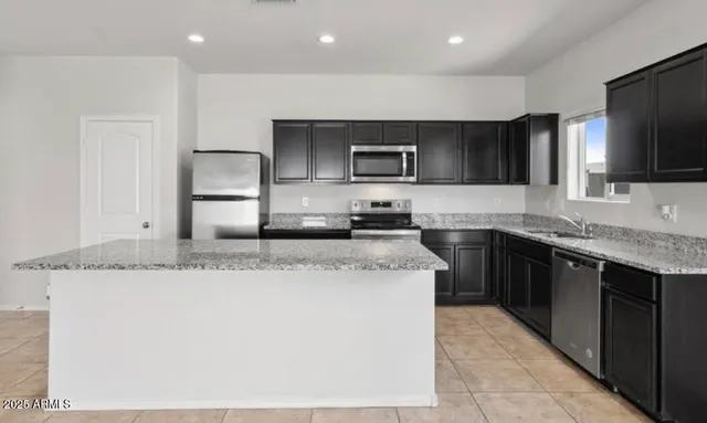 a kitchen with stainless steel appliances granite countertop a sink a stove and a refrigerator