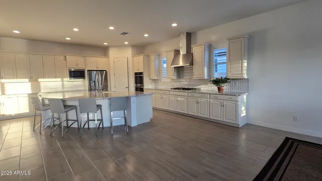 a kitchen with kitchen island granite countertop a sink cabinets and wooden floor