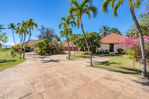 a kitchen with stainless steel appliances a microwave a stove a sink a refrigerator and white cabinets with wooden floor