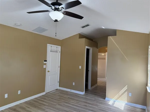 a view of an empty room with wooden floor