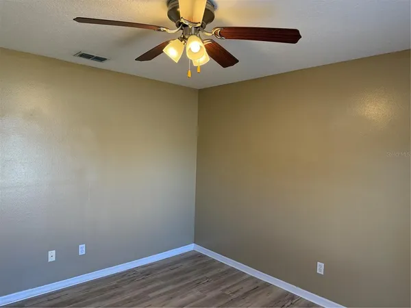 an empty room with a empty space and a ceiling fan