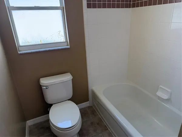 a white toilet sitting next to a bath tub