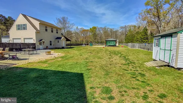 a view of a backyard with table and chairs under an umbrella