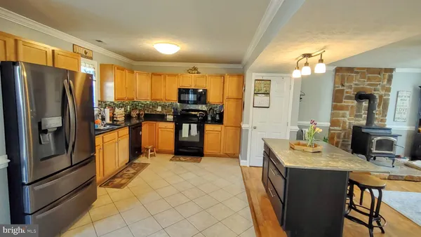 a living room with stainless steel appliances granite countertop furniture and a kitchen view