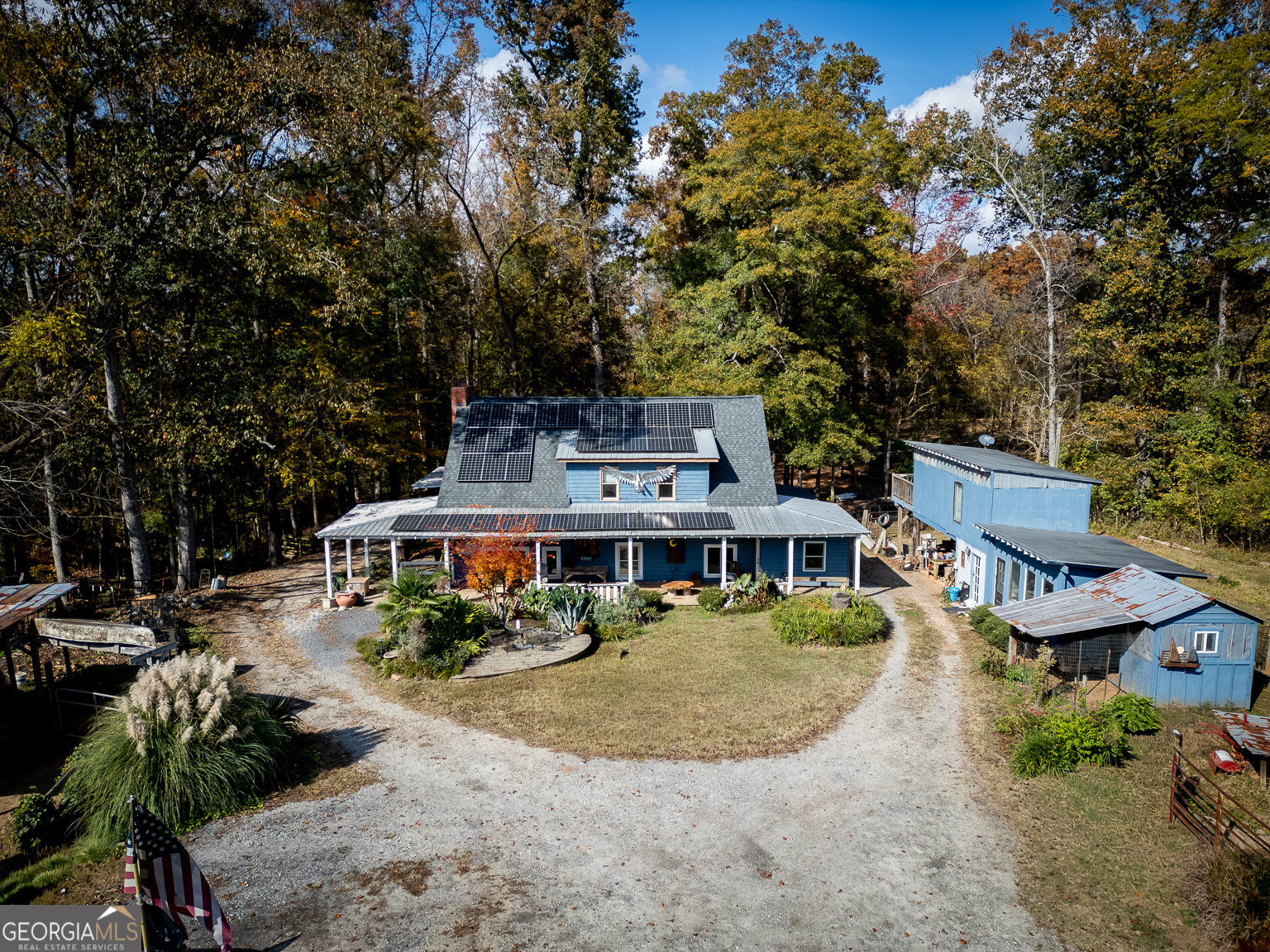 an aerial view of a house with swimming pool and large trees