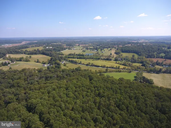 an aerial view of residential houses with outdoor space and trees