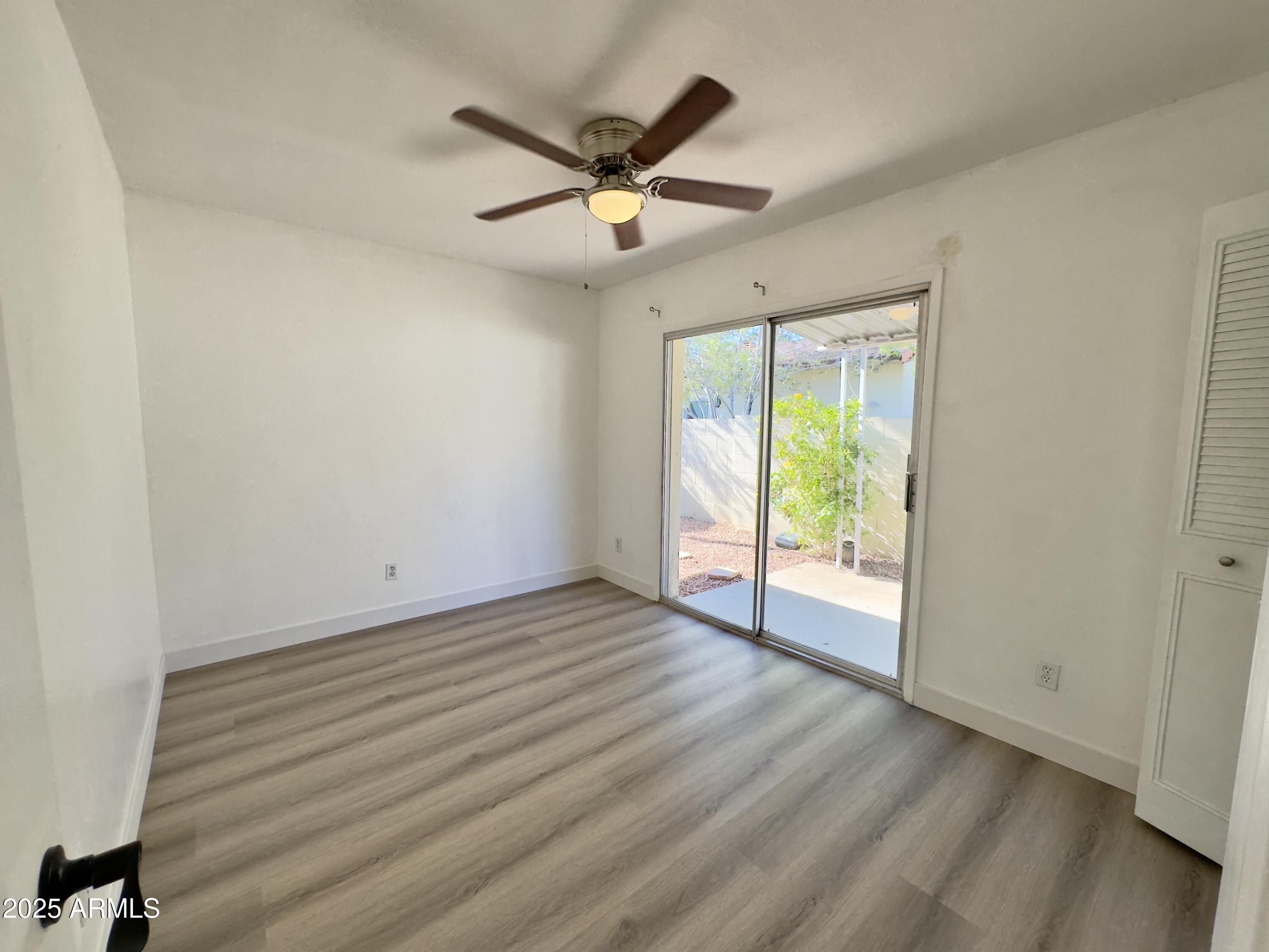 1021 West Mission Lane Phoenix, AZ 85021 - Photo 13 of 20 an empty room with wooden floor fan and windows