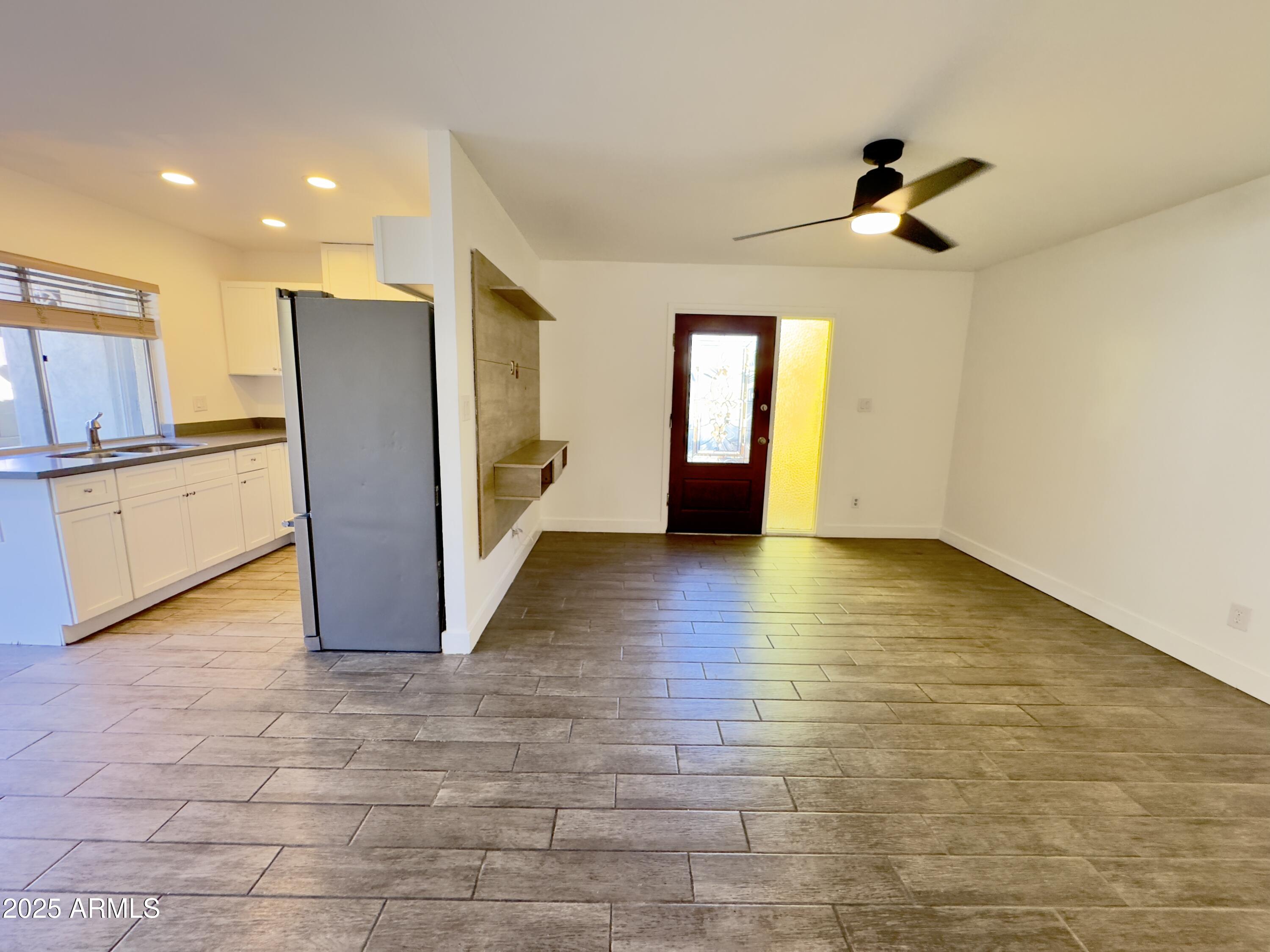 1021 West Mission Lane Phoenix, AZ 85021 - Photo 3 of 20 a view of an empty room with window and wooden floor