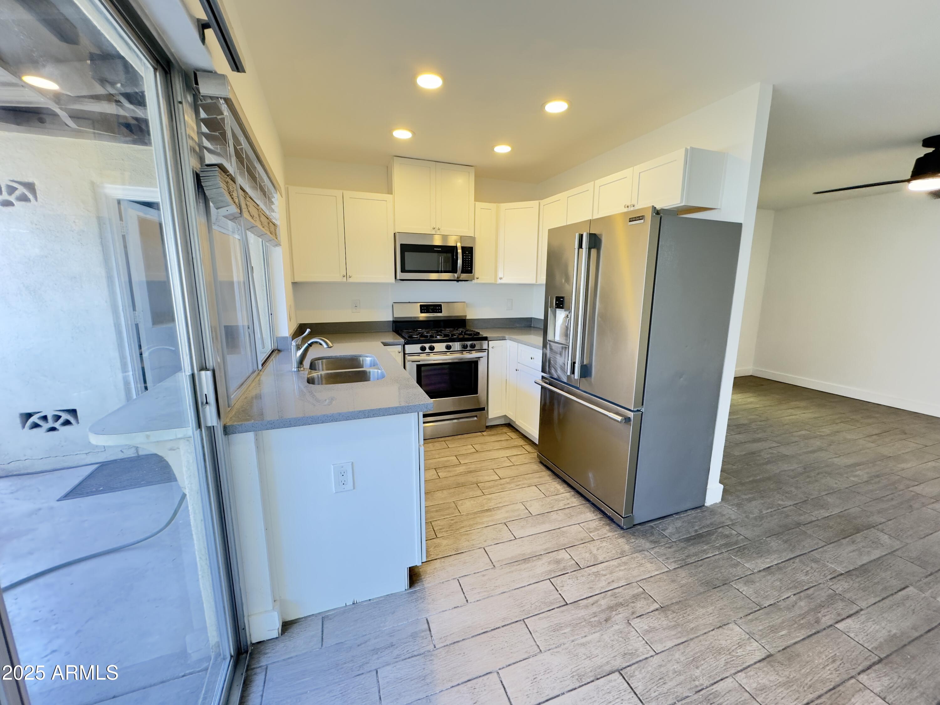 1021 West Mission Lane Phoenix, AZ 85021 - Photo 5 of 20 a kitchen with stainless steel appliances granite countertop a refrigerator stove and sink