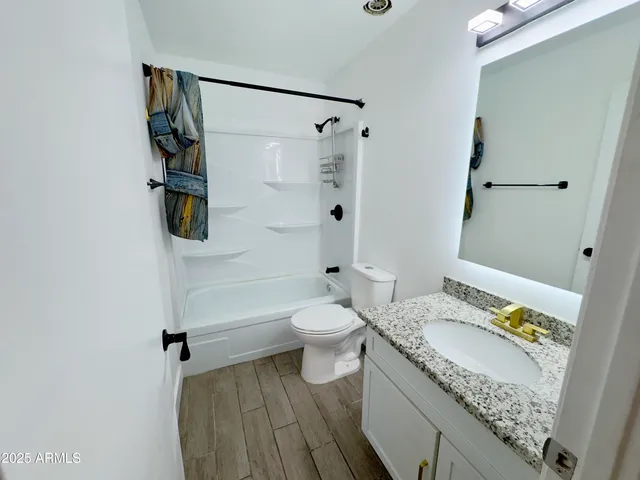 a view of a hallway with wooden floor and closet area
